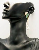 Earring on a black mannequin head with a white background