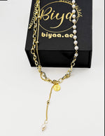 Waterproof non-tarnish artificial gold Y-necklace with paperclip chain and pearls resting on silk.