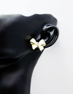 Everyday luxury fashion jewelry gold tone statement bow studs by Biya Accessoires Dubai.