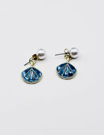 Biya Accessoires gold seashell drop earrings with blue enamel and pearl studs.