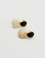 Biya Accessoires mustard and marbled white resin drop earrings.