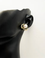 Biya Accessoires gold camellia stud earrings with black enamel and pearls.