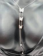 Butterfly-themed necklace on a black satin background