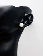 Black ear cuff with a pearl on a white background