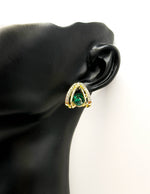 Close up of elegant imitation jewelry uae featuring a green gemstone and layered gold crystal frame.