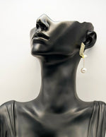 Close up of premium hypoallergenic imitation jewelry featuring a crystal arc and chain drop.