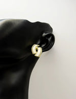 Elegant sparkling abstract earrings with white enamel details.