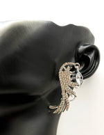 Close up of imitation jewelry uae statement earrings featuring crystal wings.