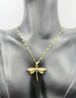 Waterproof gold insect jewelry with openwork wings on white silk.