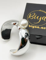 Non-tarnish thick silver statement bangle with oversized pearl Dubai luxury fashion.