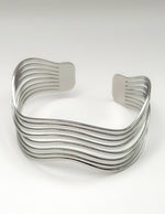 Silver wavy cuff bracelet on a white background