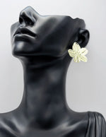 Large metallic blossom stud earrings in gold finishe.