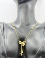 Modern luxury gold and pavé crystal bow statement lariat.