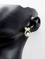 Sparkling crystal bow earrings with a luminous faux pearl center.
