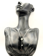 Waterproof silver Y-necklace with black and white floral pendants.