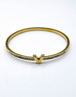 Gold bracelet with small stones on a white background