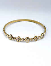 Gold bracelet with diamond accents on a white background