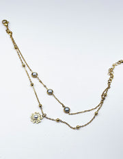 Waterproof gold layered pearl drop botanical charm bracelet for women Dubai.