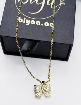 Modern luxury gold and crystal bow statement necklace for women.