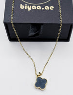 Gold necklace with a clover-shaped pendant on a white background, branded 'biyaa.ae'.