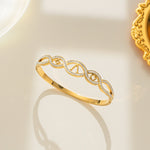 Gold bracelet with intricate design on a light background