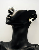 Biya Accessoires gold butterfly stud earrings with white enamel and crystals.