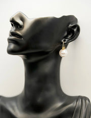 Close up of elegant imitation jewelry uae featuring a gold hoop and large round pearl.