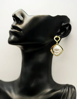 Close up of imitation jewelry uae statement drops featuring pavé stones and square pearl centers.