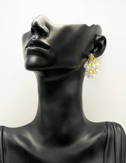 Close up of imitation jewelry uae statement studs featuring gold stems and pearl clusters.