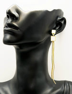 Close up of imitation jewelry uae statement drops featuring pearlescent inlay and triple chains.