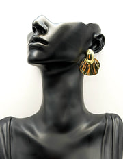 Close up of imitation jewelry uae statement studs featuring textured fan shell design.