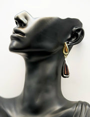 Close up of imitation jewelry uae statement earrings featuring high-shine gold and silver molten texture.