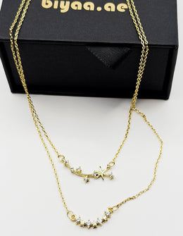 Waterproof and non-tarnish artificial gold double chain necklace resting on silk fabric.