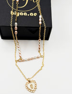 Imitation jewelry featuring a scalloped heart pendant and faux pearls by Biya Accessoires.