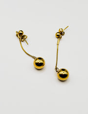 Biya Accessoires 18K gold plated minimalist sphere drop earrings with snake chain.