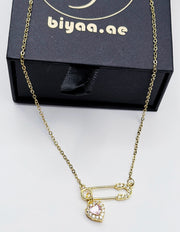 Biya Accessoires 18K gold plated safety pin necklace with pink heart crystal.