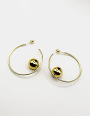 Close up of elegant imitation jewelry uae featuring oversized hoops and polished gold balls.
