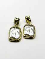 Close up of imitation jewelry uae statement drops featuring textured metal and pearlescent resin.