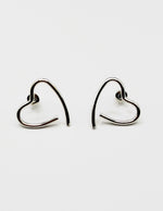 Biya Accessoires silver open heart ear crawler earrings.