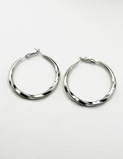 Biya Accessoires silver oversized twisted hoop earrings.