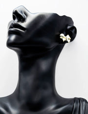 Biya Accessoires gold and pearlescent bow stud earrings with crystal center.