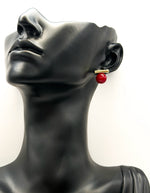 Mannequin head wearing a red earring with gold accent