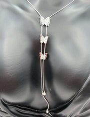 Butterfly-themed necklace on a black satin background