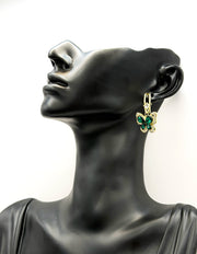 Close up of imitation jewelry uae statement drops featuring emerald pavé wings.