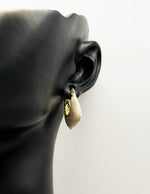 Close up of imitation jewelry uae statement hoops featuring gilded hardware.