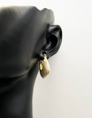 Close up of imitation jewelry uae statement hoops featuring gilded hardware.
