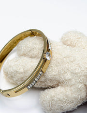 Biya Accessoires 18K gold plated bangle with central solitaire stone and crystal accents.