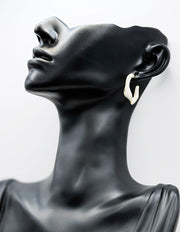 Biya Accessoires gold and cream marbled twisted hoop earrings.