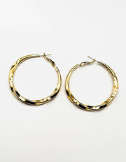 Biya Accessoires gold oversized twisted hoop earrings.