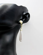 Close-up of premium hypoallergenic imitation jewelry featuring a pearlescent bar and gold stud.
